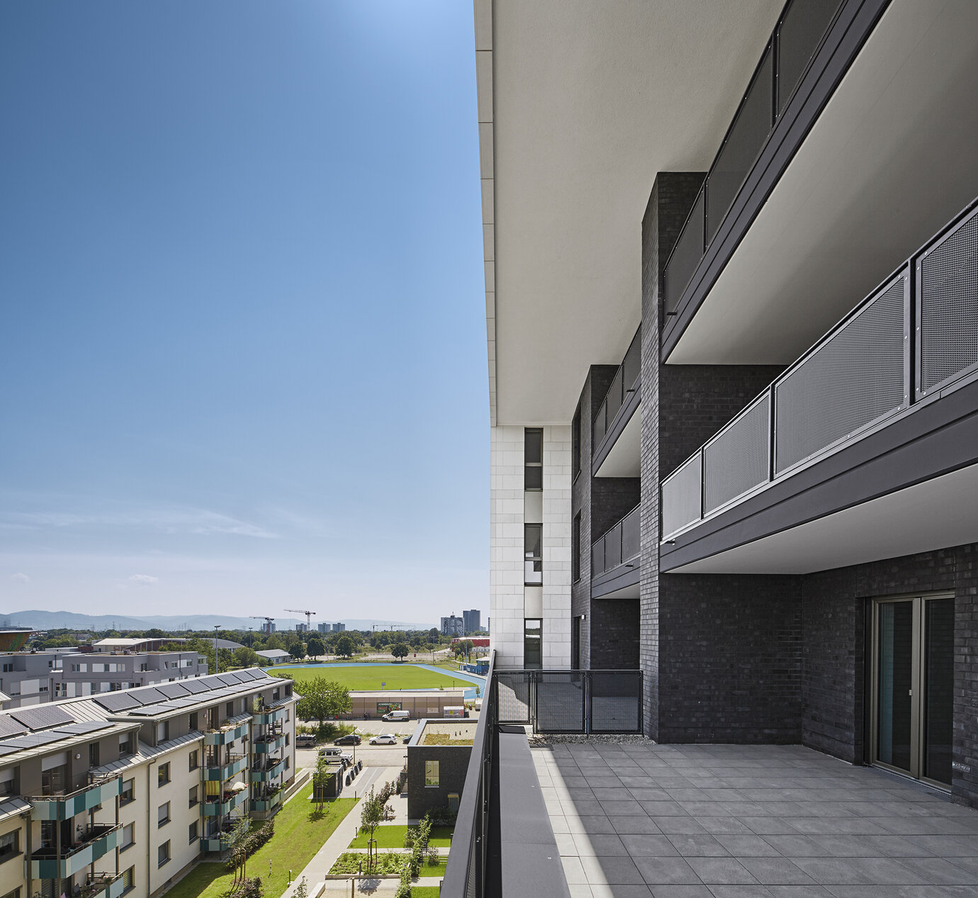 Rücksprünge der Kubatur lassen Platz für großflächige Dachterrassen und weit offene Balkone.